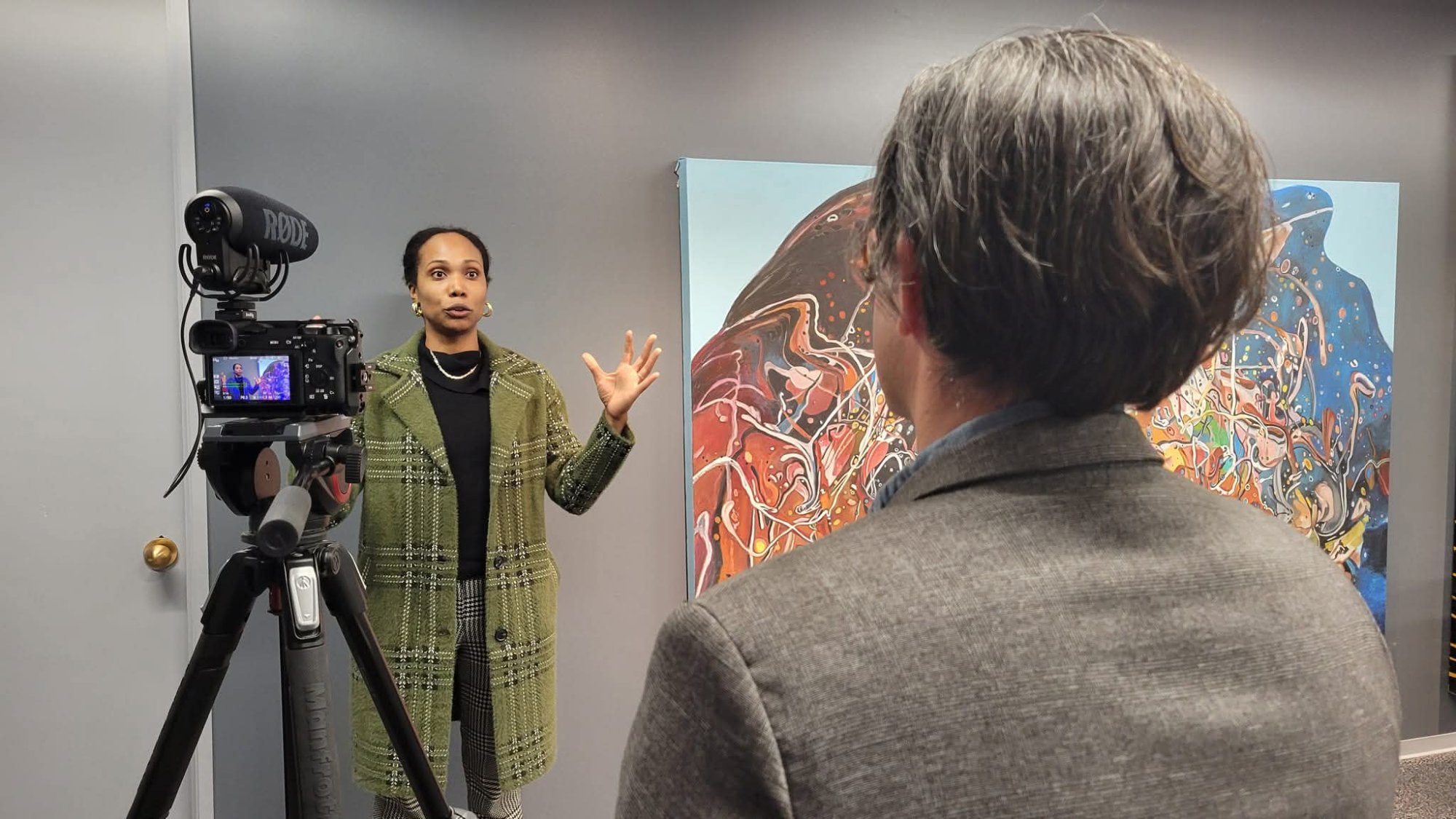 Corporate video interview with RODE mic and colorful art backdrop